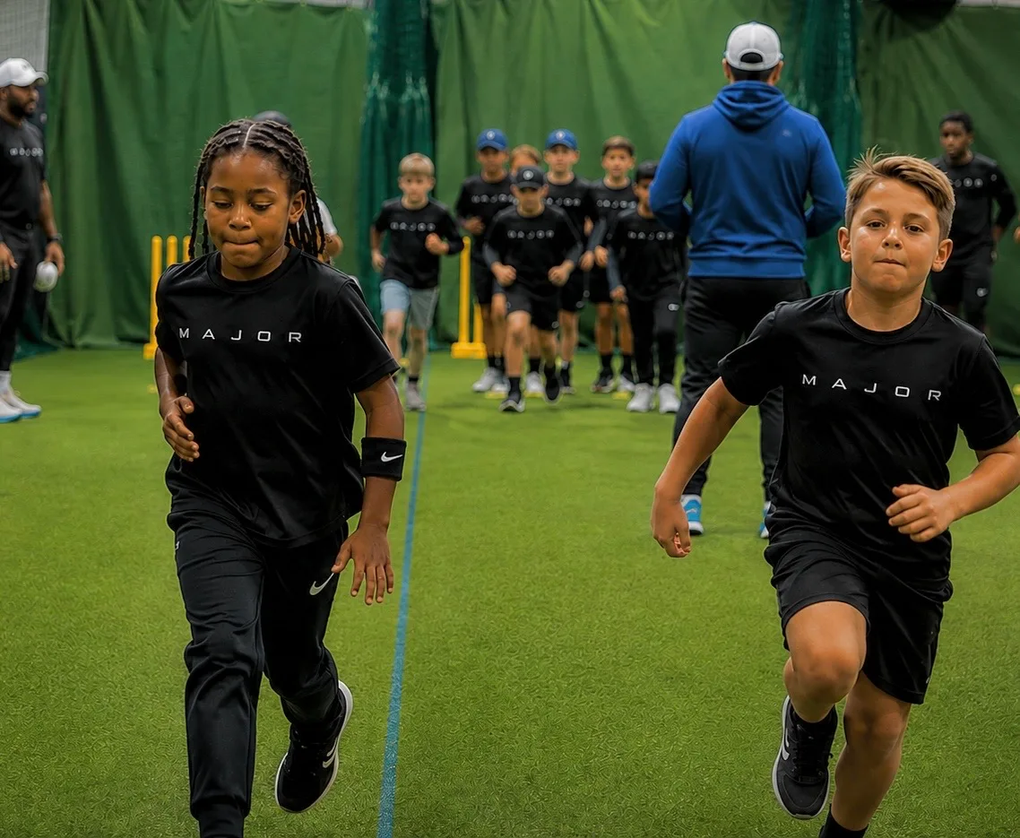 Kids in black MAJOR shirts running on indoor turf